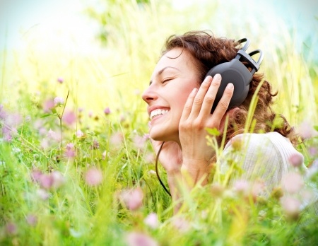 14646697 - beautiful young woman with headphones outdoors enjoying music